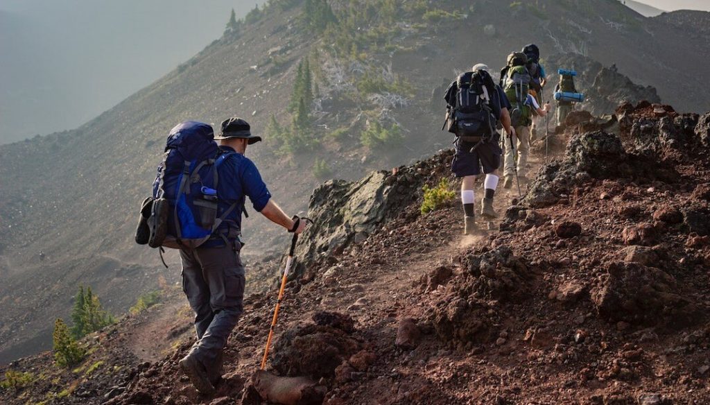 People hiking with big backpacks, carrying necessary gear and supplies, a must-have gear for every hiker.